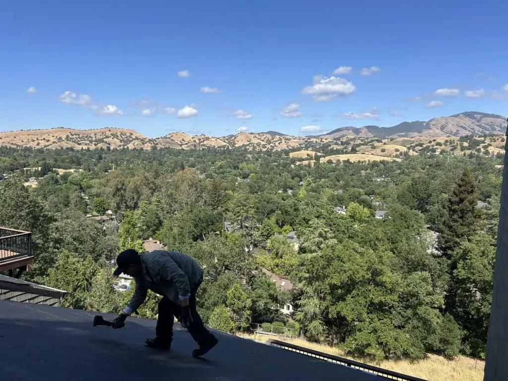 A man is in the top of the roof doing some repairs