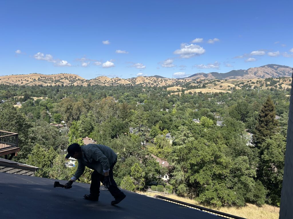 A man is in the top of the roof doing some repairs
