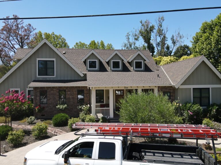 A pick up truck parked on the side of the road with big house in the background