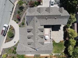 A clear aerial shot of a mansion with multiple attic rooms can be seen