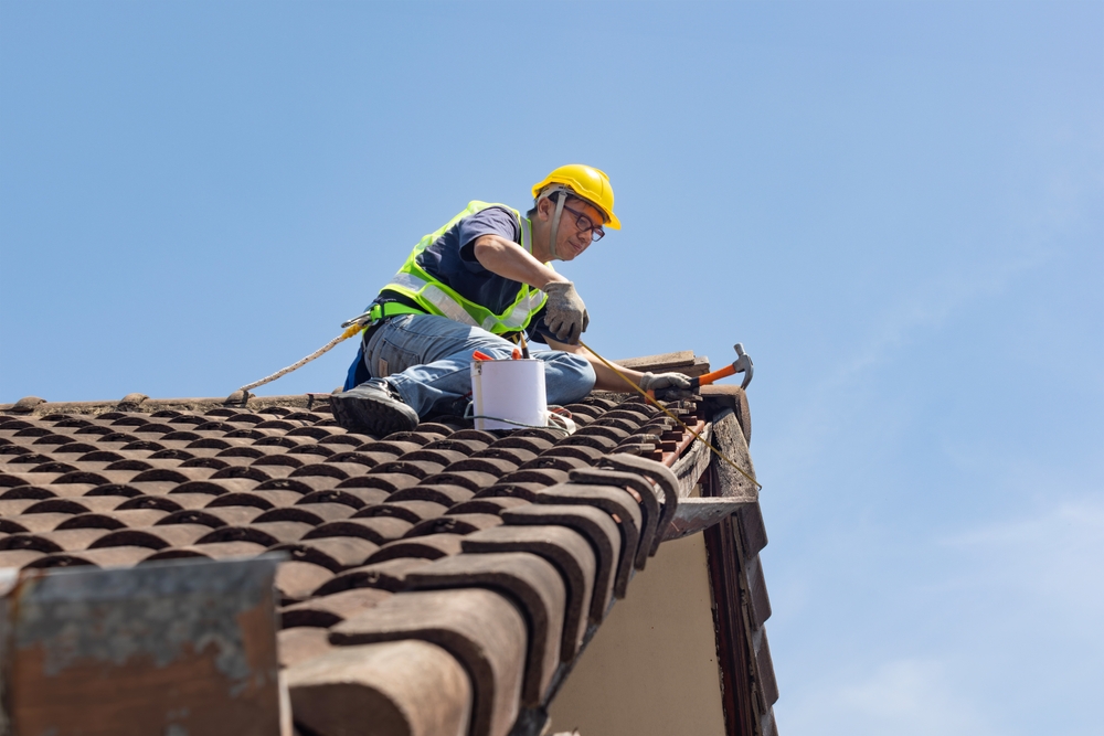 A worker is repairing the old roof tile
