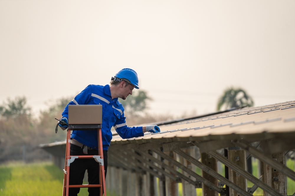 A roofing experts in uniform carefully inspects a house roof